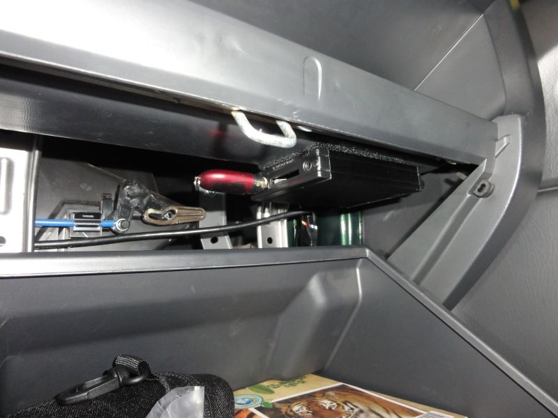 I suggest to to fix it under the top of the glovebox with a velcro hook.